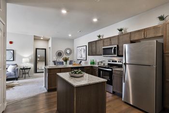 an open kitchen with stainless steel appliances and a granite counter top  at Aventura at Hawk Ridge, Lake St Louis